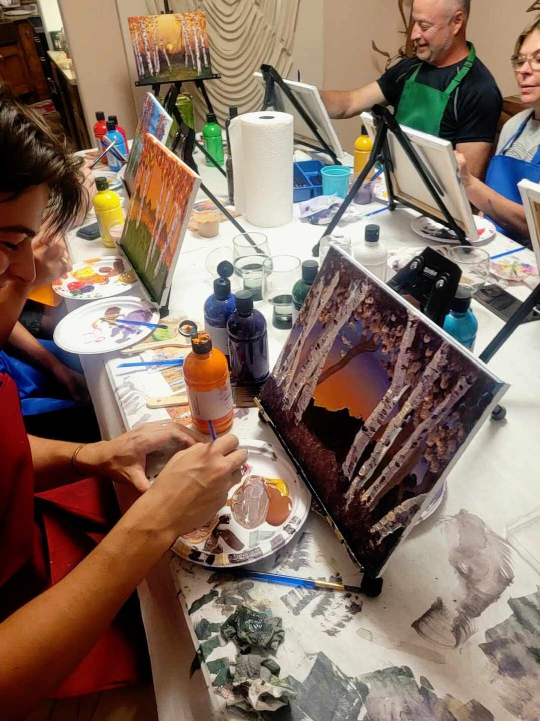 Intimate Home Paint Party Setting A table setup with canvases and paints, preparing for a paint party in a home.